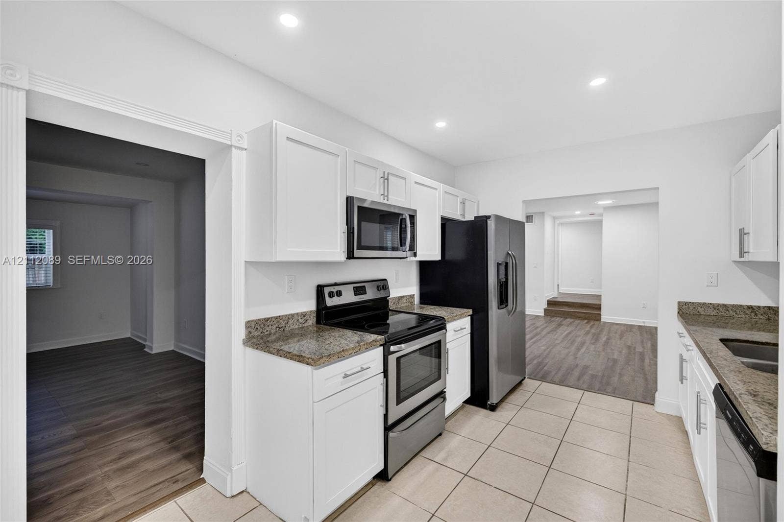 2017 NE 29th Court, Fort Lauderdale, FL 33306 Kitchen featuring white cabinetry, stone-finish countertops, stainless steel appliances, and tile flooring