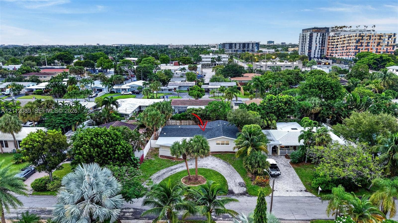 2017 NE 29th Court, Fort Lauderdale, FL 33306 Aerial perspective of a detached residence featuring a shingled roof, curved paved driveway, and mature landscaping