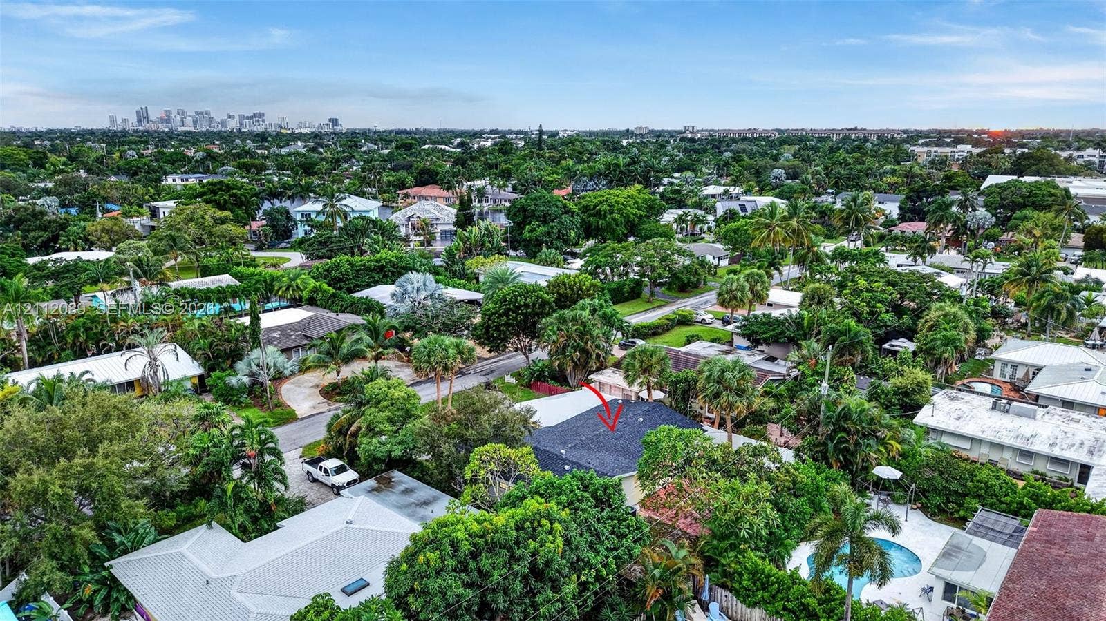 2017 NE 29th Court, Fort Lauderdale, FL 33306 Aerial perspective featuring a dark shingle roof, established canopy trees, and an expansive residential landscape