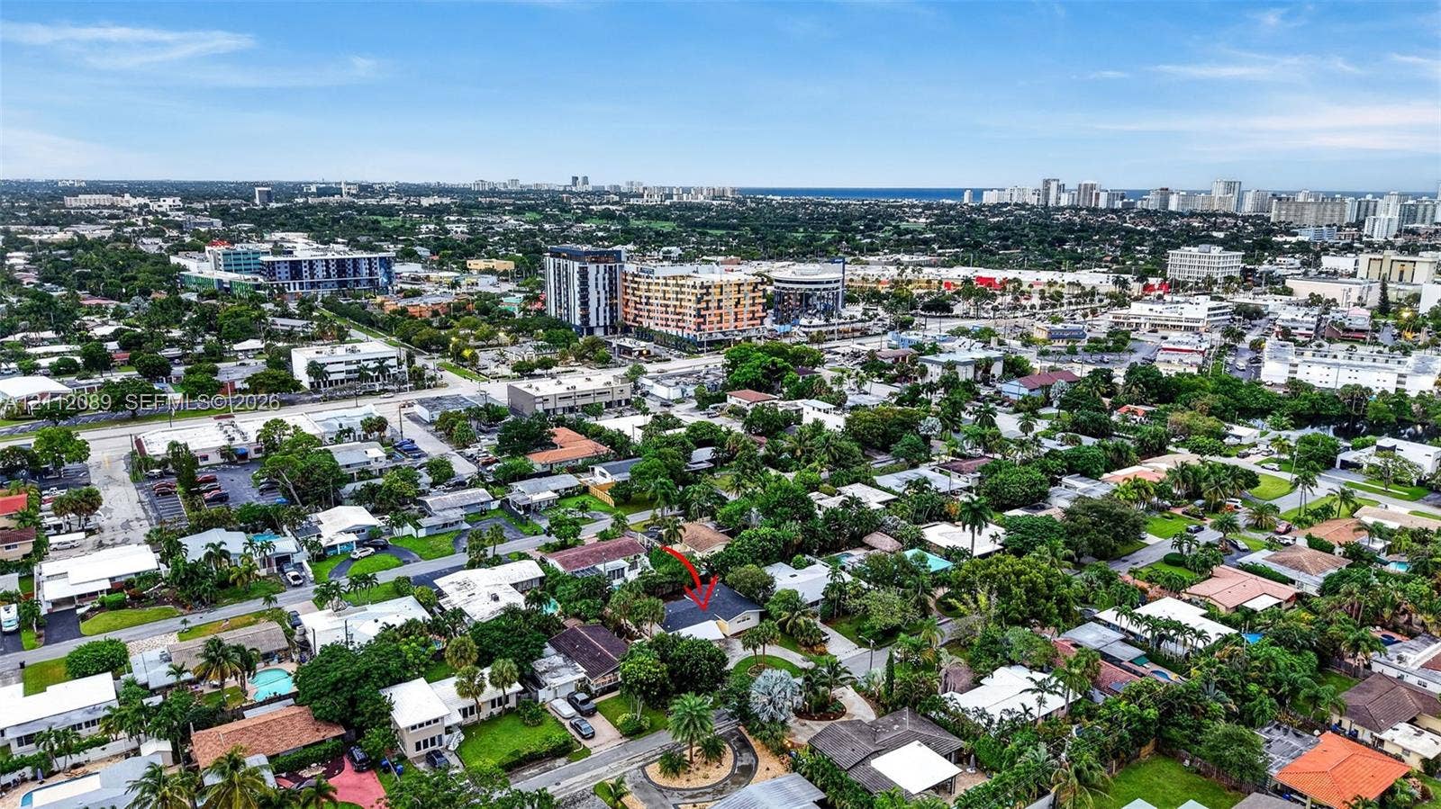 2017 NE 29th Court, Fort Lauderdale, FL 33306 Aerial perspective of a residential property featuring a pitched roof, mature canopy trees, and established landscaping, situated within a dense urban environment with proximity to commercial infrastructure