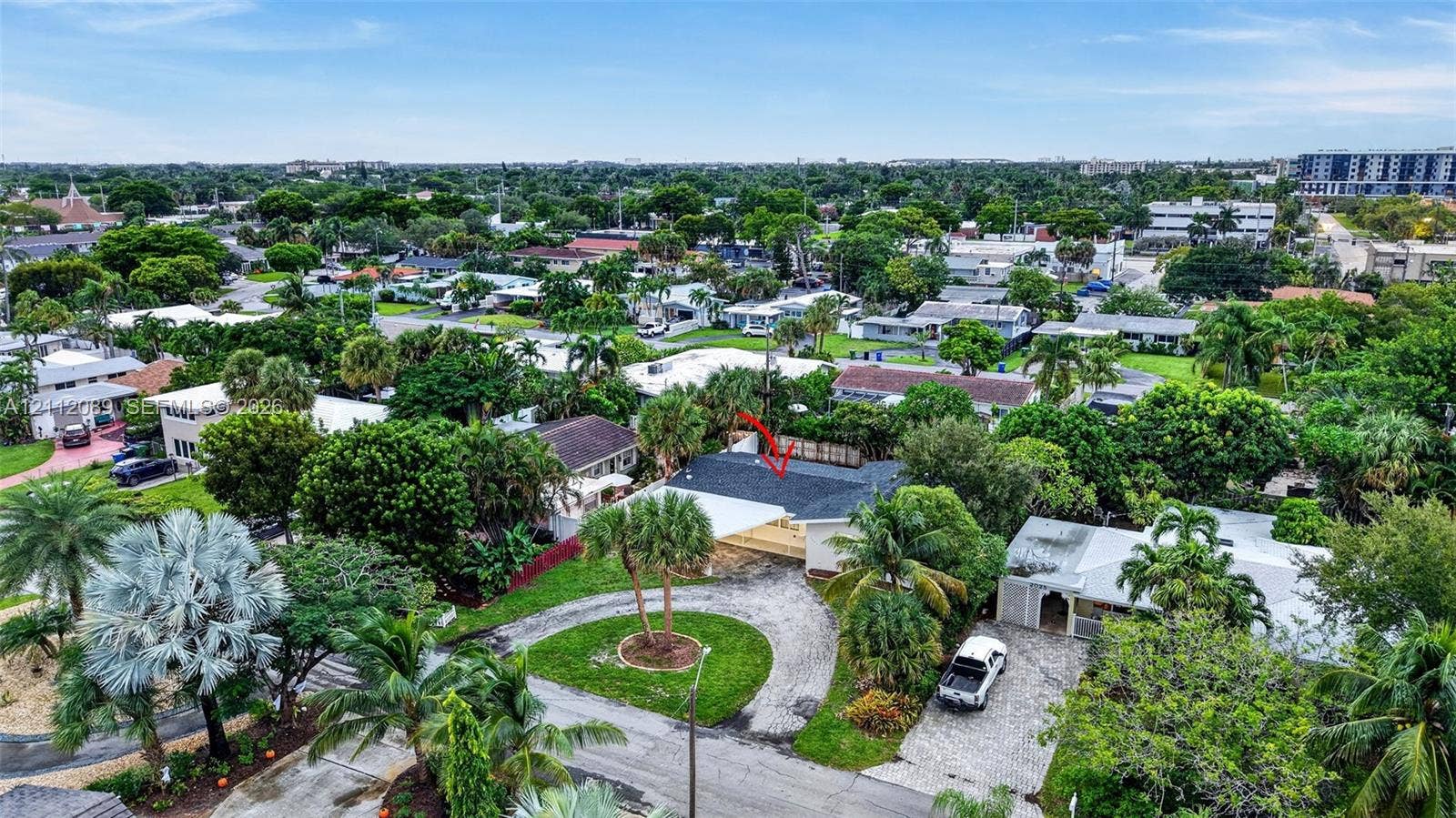 2017 NE 29th Court, Fort Lauderdale, FL 33306 Aerial perspective featuring a shingled roof, circular driveway, mature landscaping, and an expansive lot