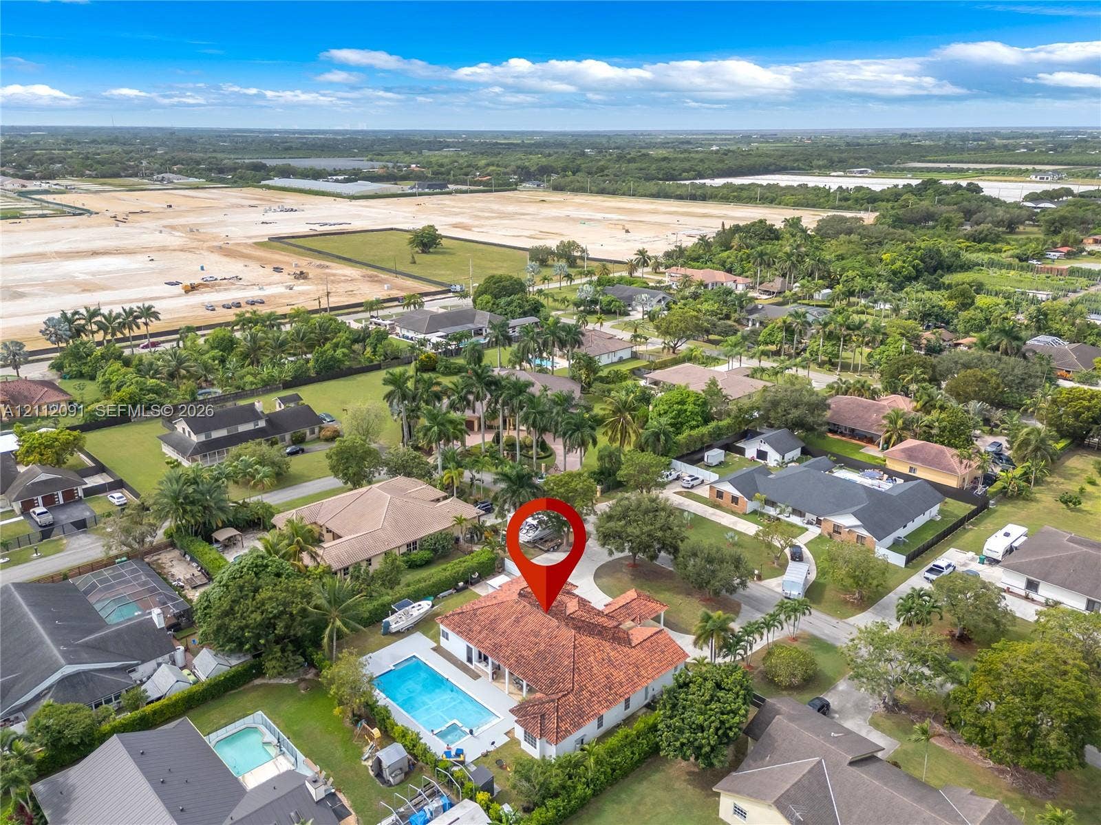 29481 SW 193rd Court, Homestead, FL 33030 Aerial perspective featuring a tile roof, an in-ground swimming pool, and mature perimeter landscaping