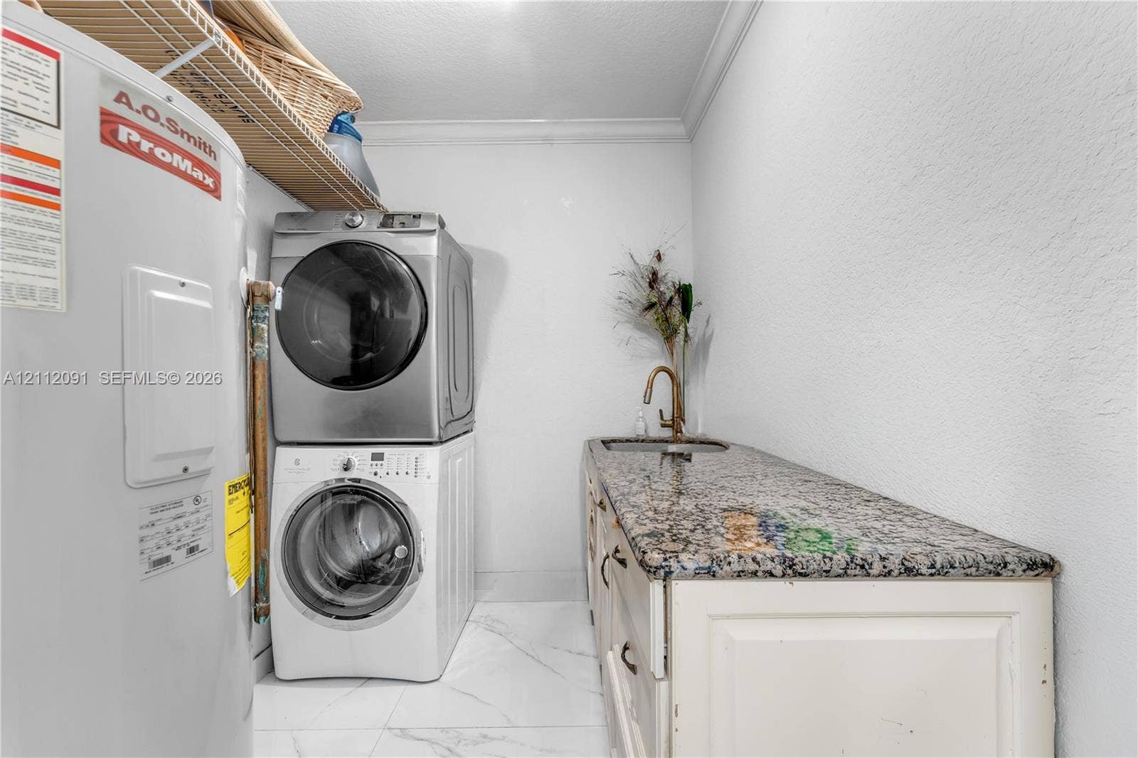 29481 SW 193rd Court, Homestead, FL 33030 Utility area featuring a built-in cabinet with stone-finish countertop, undermount sink, gooseneck faucet, and white tile flooring