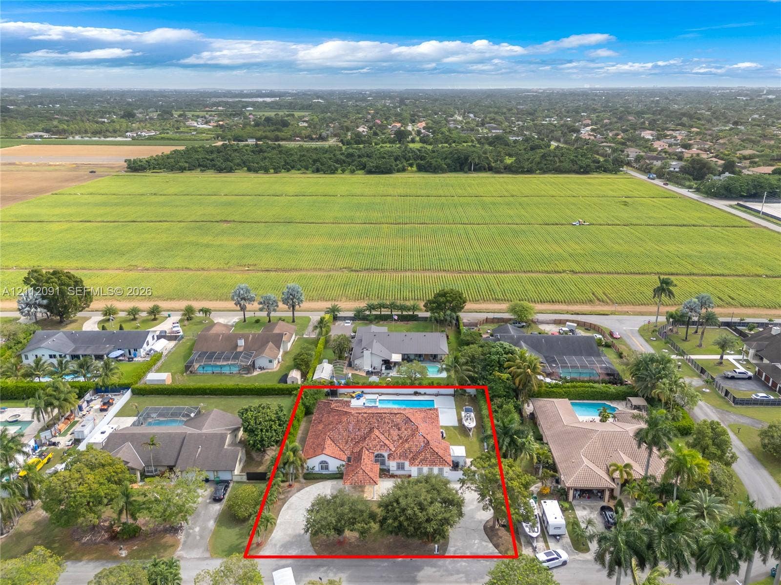 29481 SW 193rd Court, Homestead, FL 33030 Single-story residence featuring a tile roof, circular driveway, swimming pool, and mature perimeter landscaping