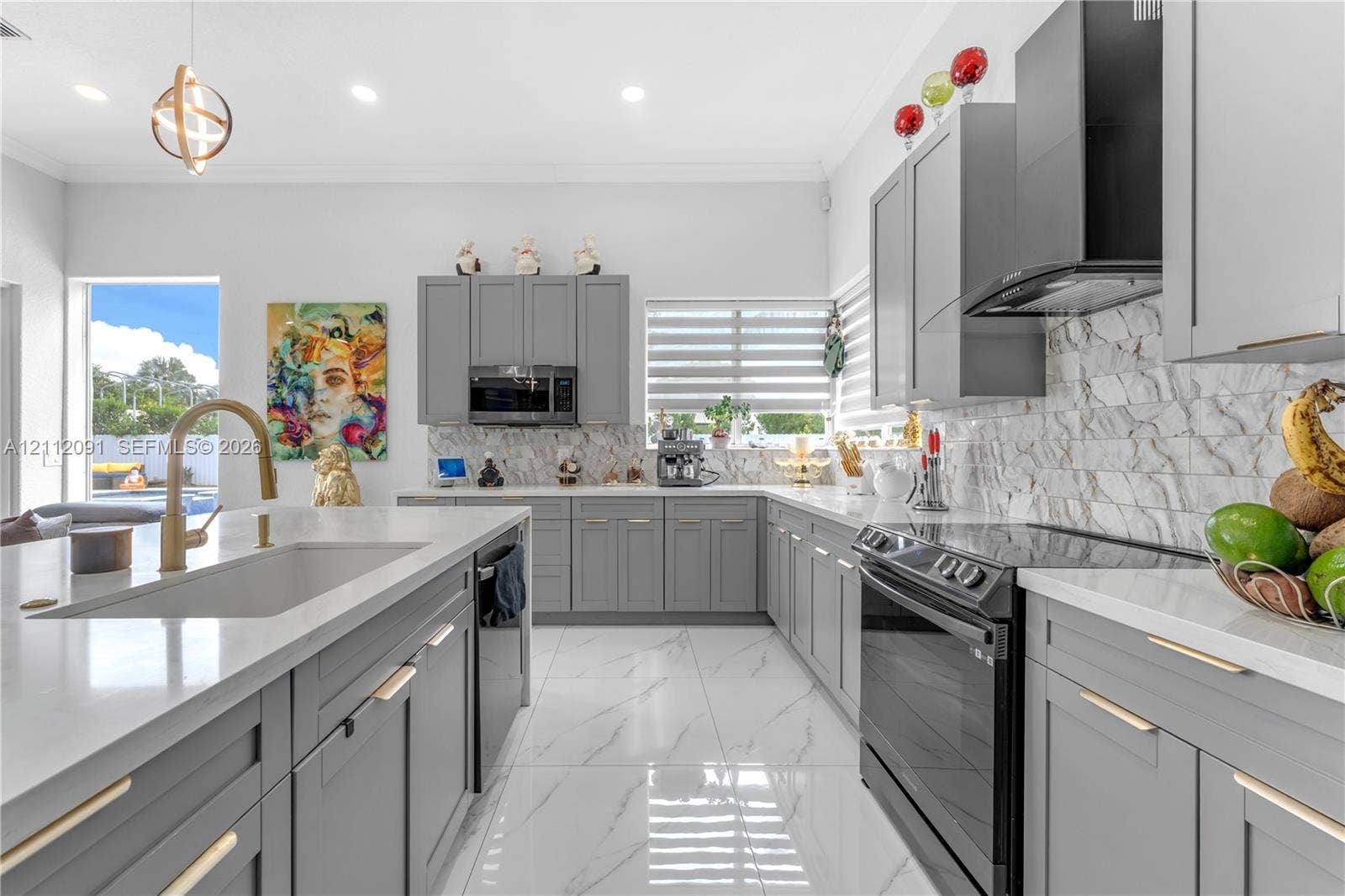 29481 SW 193rd Court, Homestead, FL 33030 Kitchen featuring gray Shaker-style cabinetry, white solid-surface countertops, stone-tile backsplash, stainless steel appliances, and large-format porcelain tile flooring