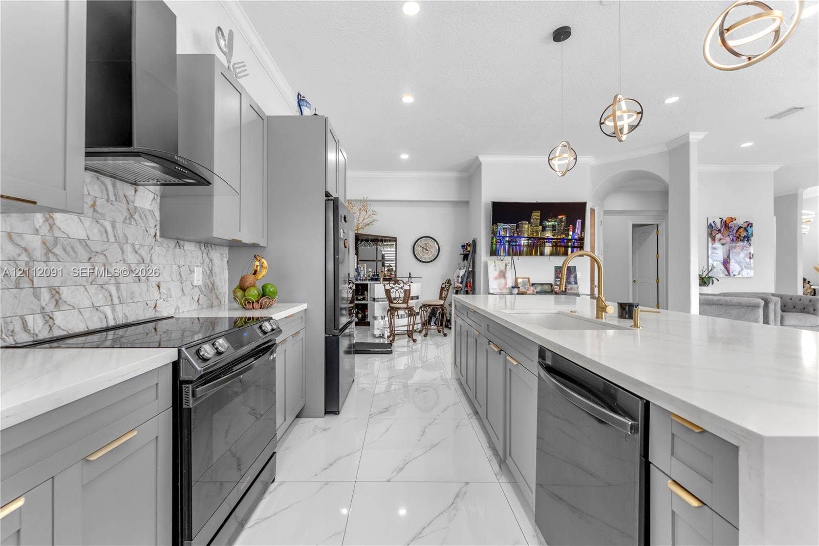29481 SW 193rd Court, Homestead, FL 33030 Kitchen featuring gray shaker-style cabinetry, a stone-pattern backsplash, quartz countertops, a central island with a gold-finish faucet, and large-format porcelain tile flooring