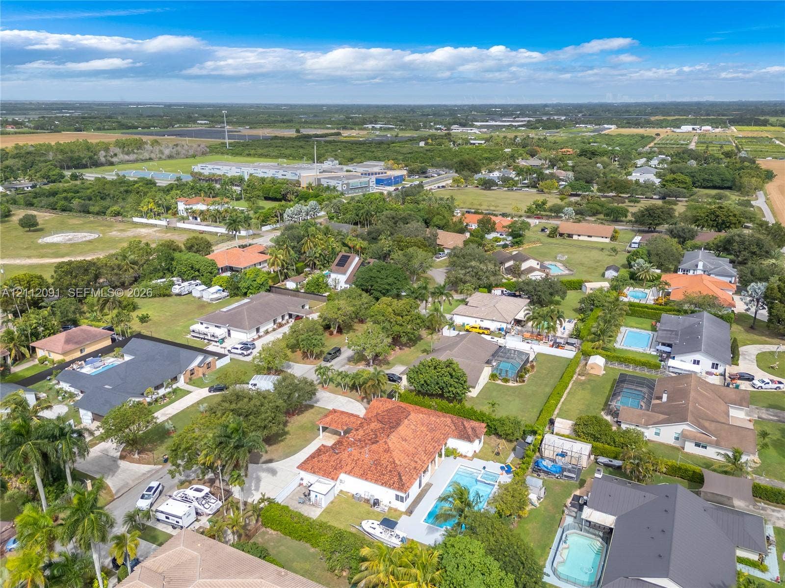 29481 SW 193rd Court, Homestead, FL 33030 Aerial perspective featuring a residence with a clay tile roof, concrete driveway, and in-ground swimming pool