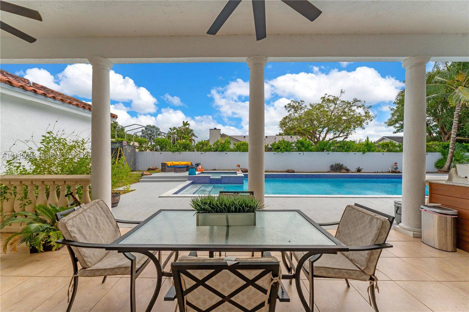 29481 SW 193rd Court, Homestead, FL 33030 Covered patio featuring tiled flooring, structural columns, ceiling fans, and a tiled swimming pool with an integrated spa