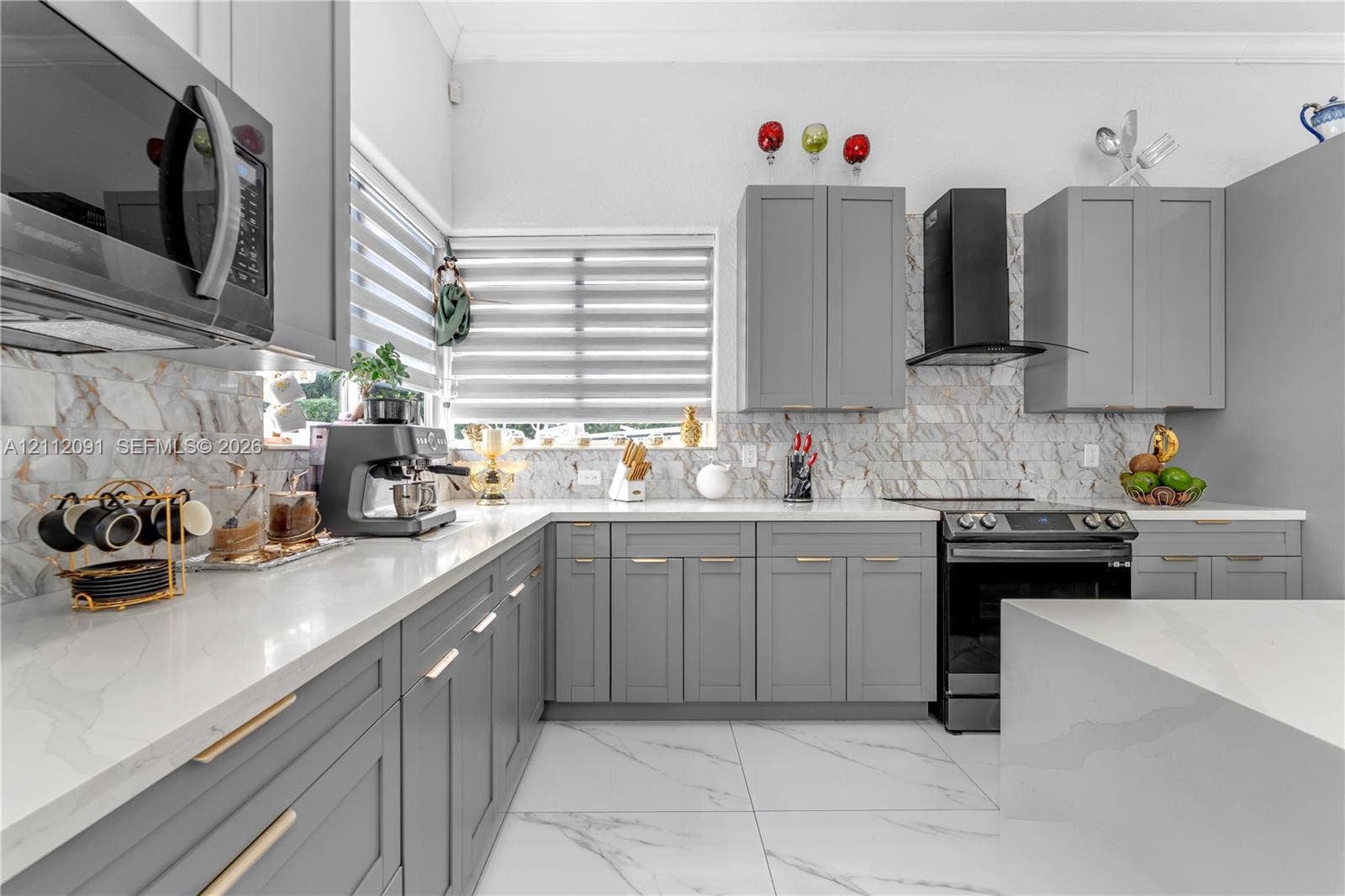 29481 SW 193rd Court, Homestead, FL 33030 Kitchen featuring shaker-style cabinetry, white countertops, stone-patterned backsplash, large-format tile flooring, and stainless steel appliances