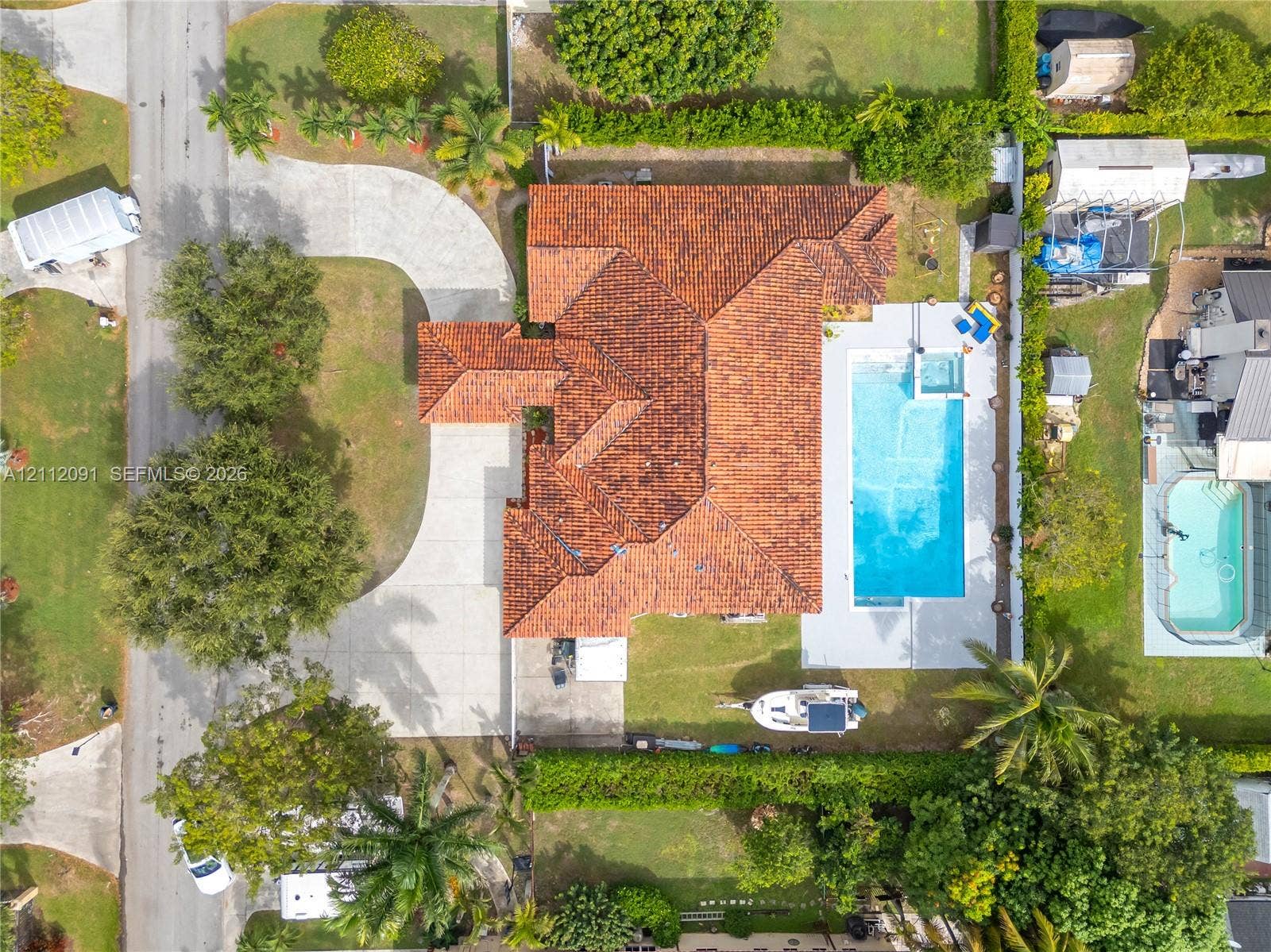 29481 SW 193rd Court, Homestead, FL 33030 Aerial perspective featuring a tile roof, concrete driveway, and an in-ground pool with a surrounding patio