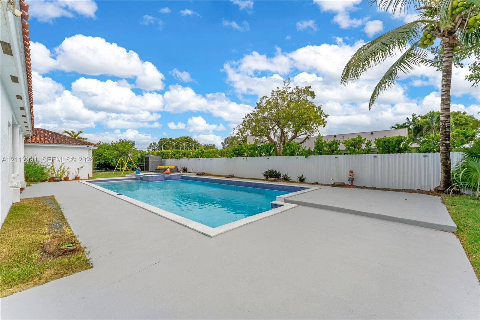 29481 SW 193rd Court, Homestead, FL 33030 Outdoor swimming pool with integrated spa, concrete decking, and privacy fencing