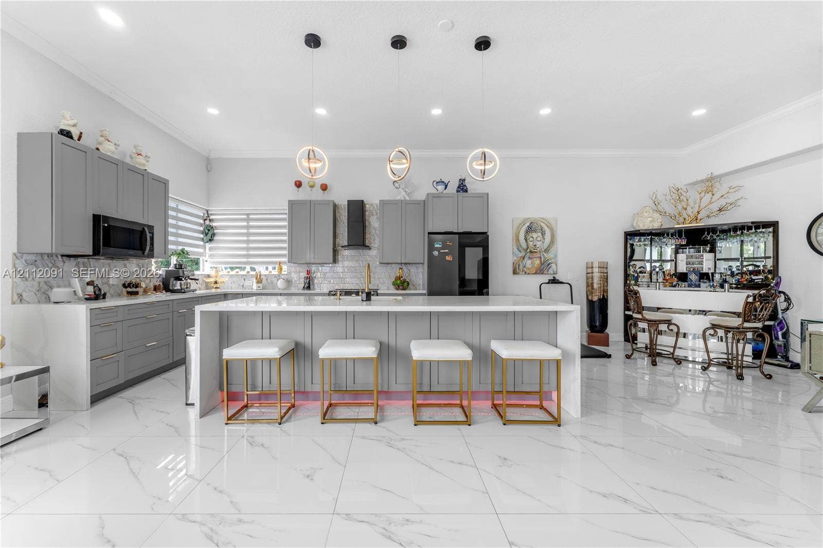 29481 SW 193rd Court, Homestead, FL 33030 Kitchen featuring light-gray shaker-style cabinetry, quartz countertops, a stone-tile backsplash, polished large-format tile flooring, and three contemporary spherical pendant lights suspended over a central island