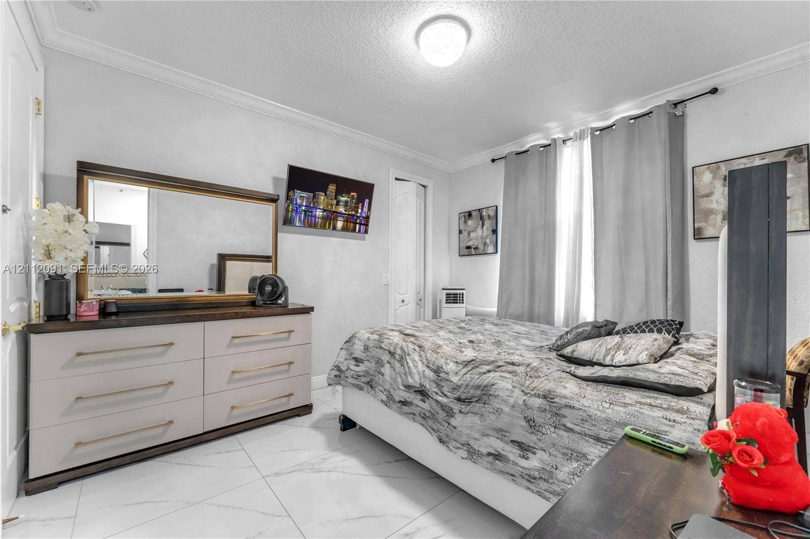 29481 SW 193rd Court, Homestead, FL 33030 Room featuring large-format tile flooring with a neutral veined pattern, crown molding, and a central flush-mount ceiling light fixture