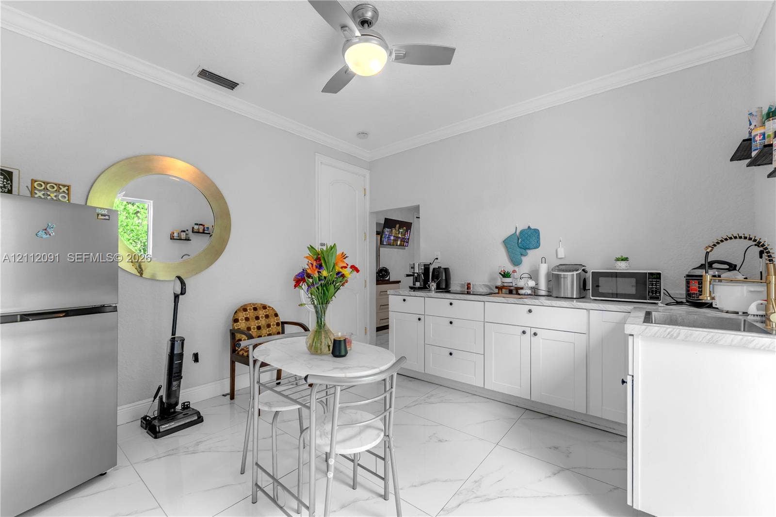 29481 SW 193rd Court, Homestead, FL 33030 Kitchen featuring white shaker-style cabinetry, solid-surface countertops, large-format tile flooring, a stainless steel refrigerator, and a ceiling-mounted light fixture