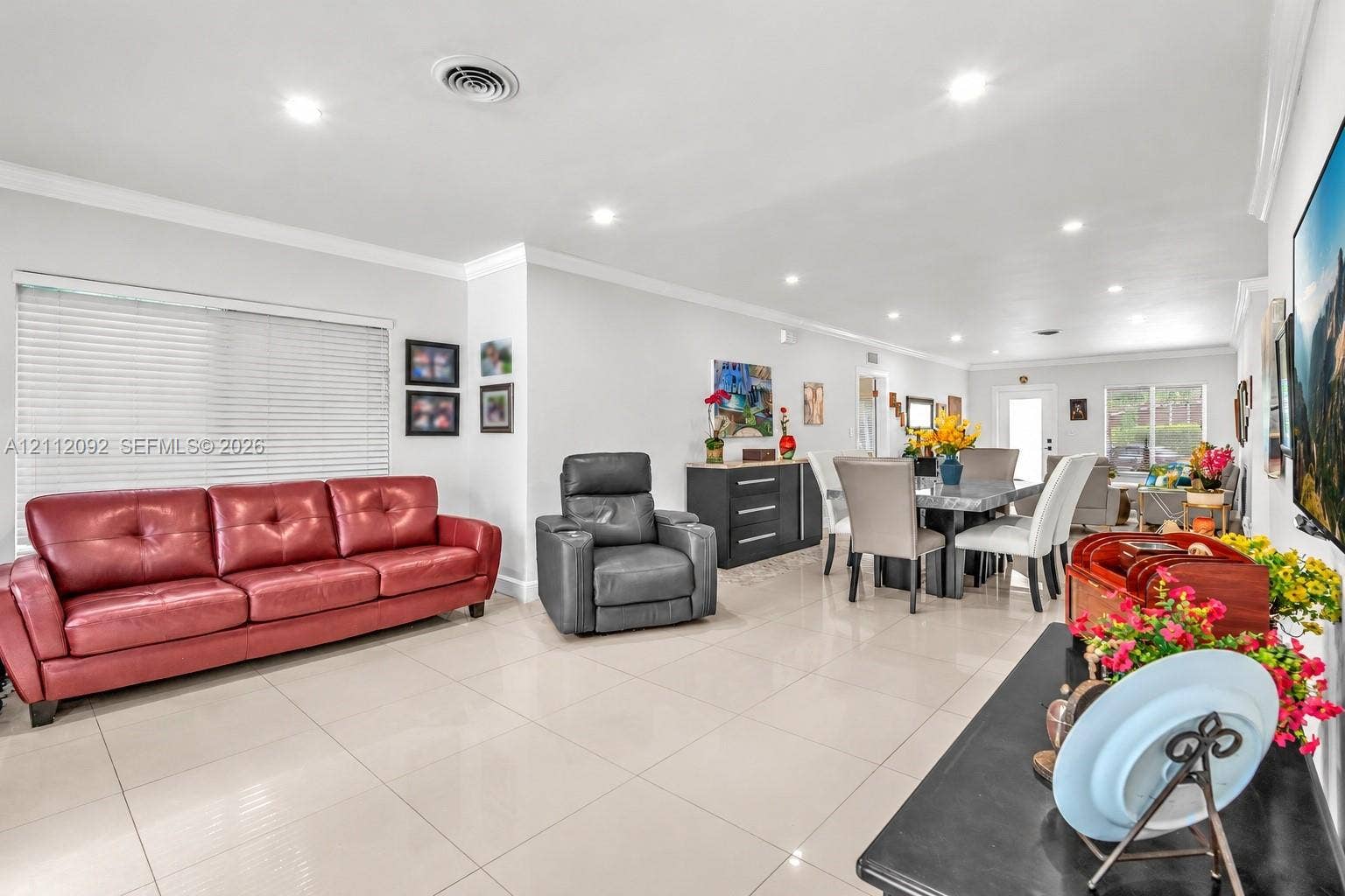 419 Sevilla Avenue, Coral Gables, FL 33134 Open-concept interior featuring large-format tile flooring, recessed ceiling lighting, crown molding, and expansive windows with installed blinds