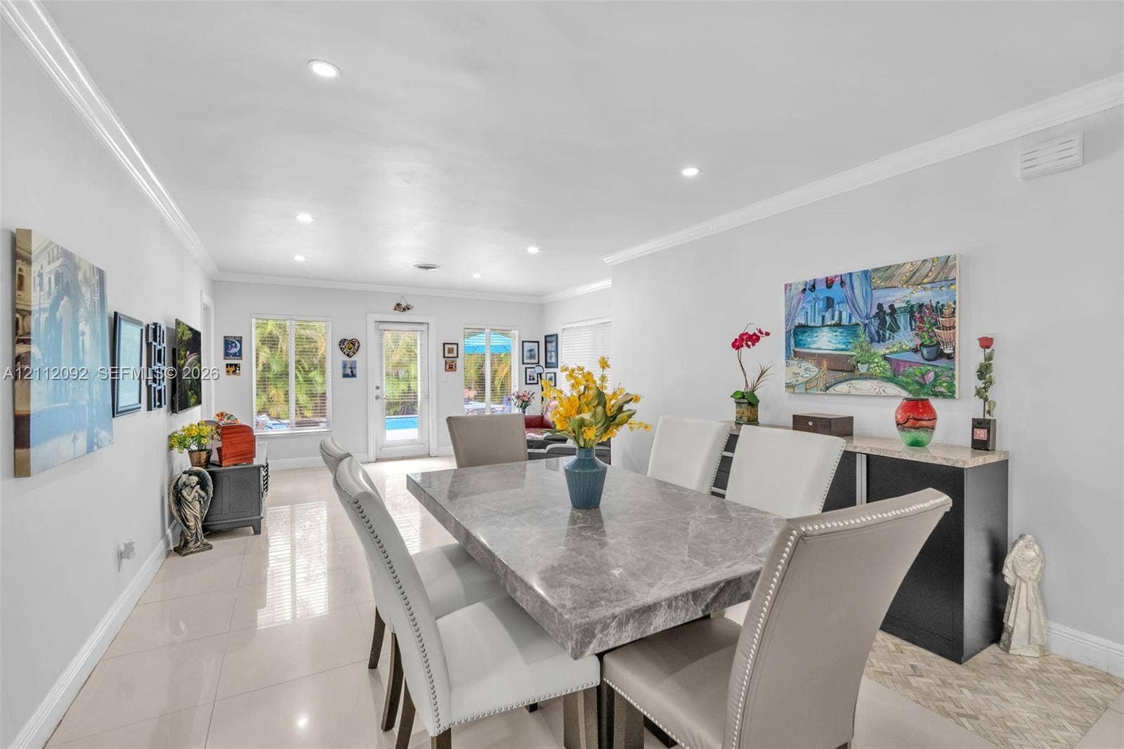 419 Sevilla Avenue, Coral Gables, FL 33134 Open-concept interior featuring large-format tile flooring, recessed lighting, crown molding, and a glass-paneled exterior door
