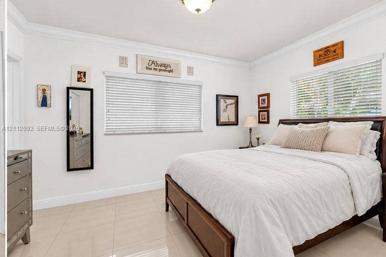 419 Sevilla Avenue, Coral Gables, FL 33134 Room featuring large-format tile flooring, crown molding, and dual windows with horizontal blinds