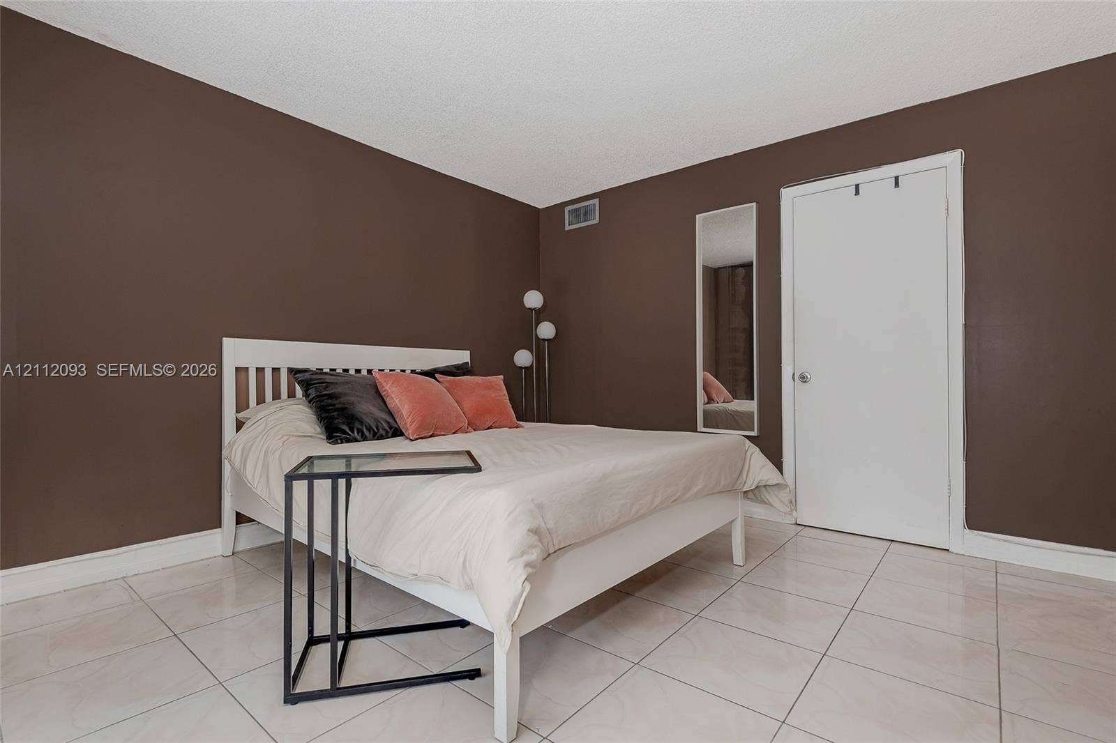 2750 NE 183rd Street, #1612, Aventura, FL 33160 Room featuring neutral wall tones, large-format tile flooring, a solid-core interior door, and a built-in wall-recessed mirror