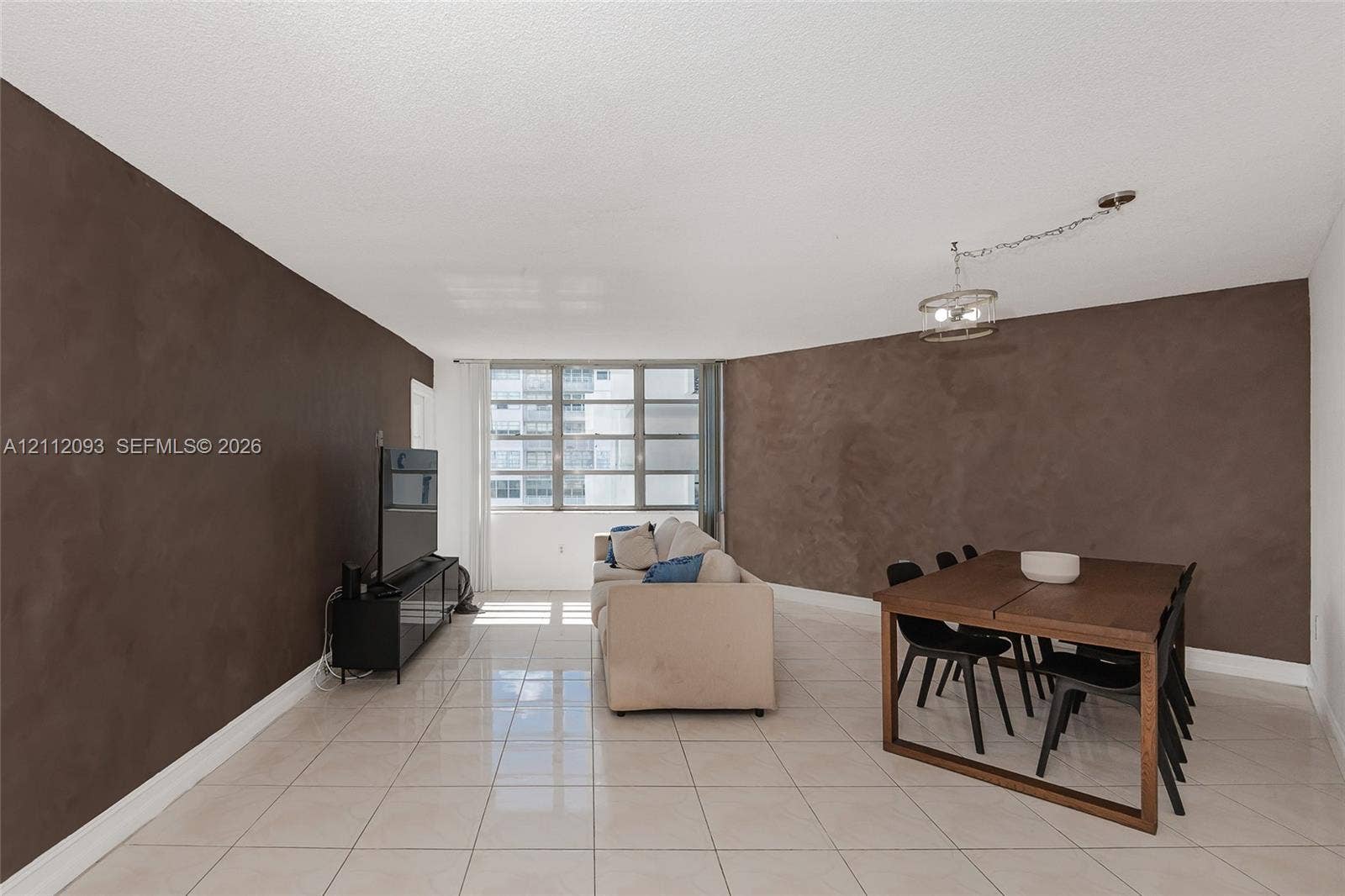 2750 NE 183rd Street, #1612, Aventura, FL 33160 Open floor plan featuring large-format ceramic tile flooring, textured accent walls, and floor-to-ceiling multi-pane windows