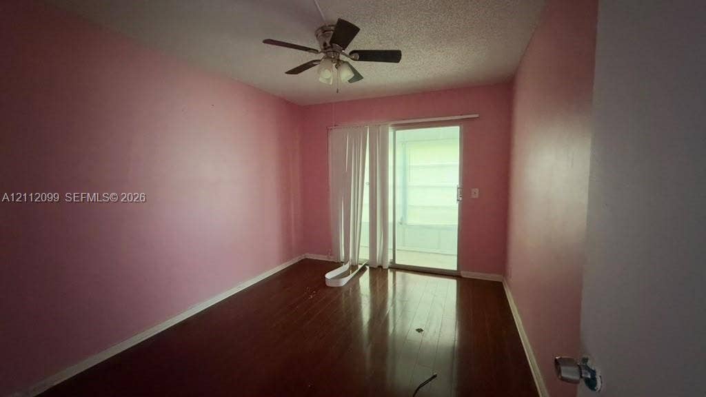 256 Fanshaw G, #2560, Boca Raton, FL 33434 Room featuring wood-finish flooring, a ceiling fan with integrated lighting, and a sliding glass door