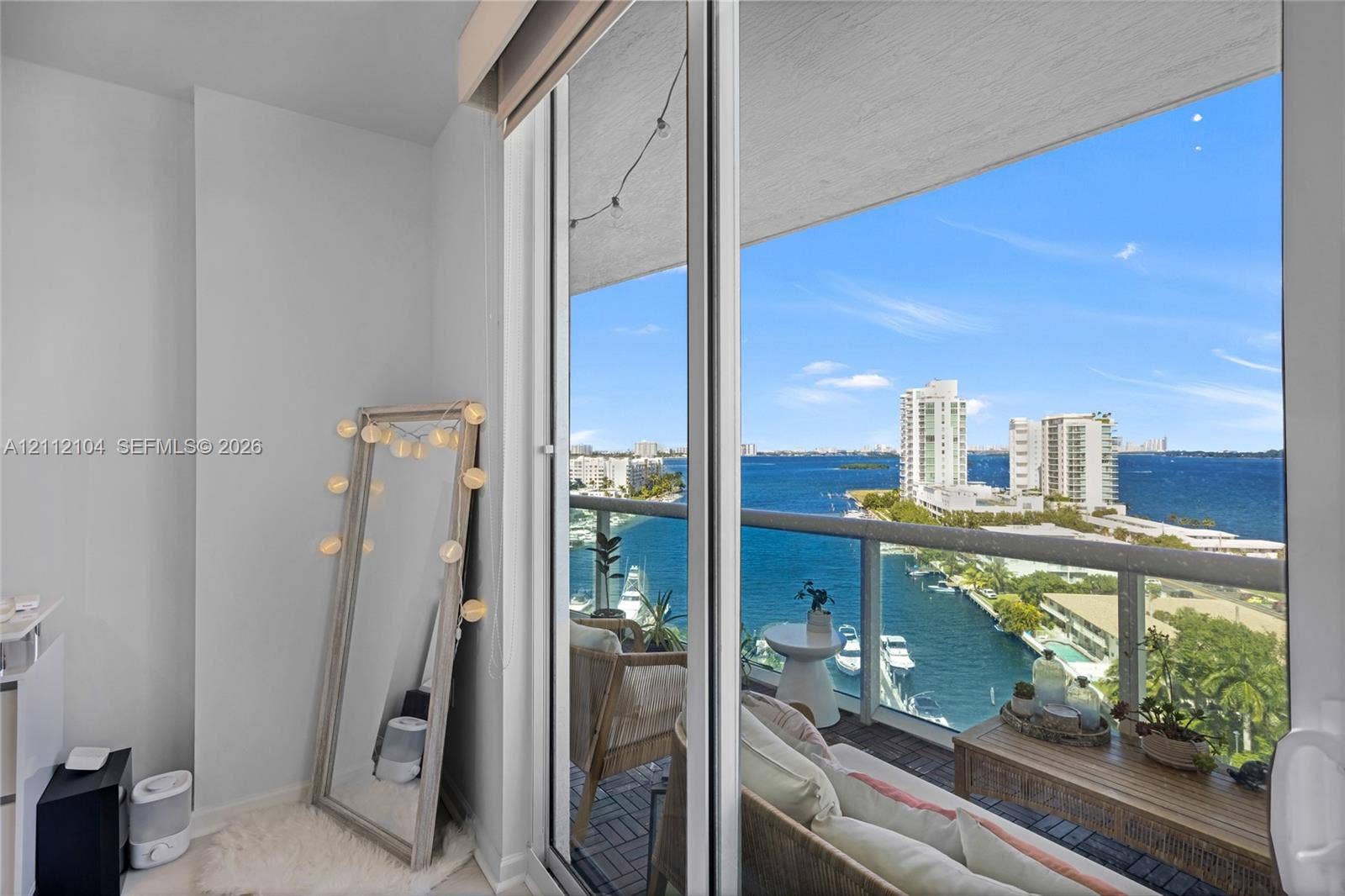 7900 Harbor Island Drive, #1203, North Bay Village, North Bay Village, FL 33141 Full-height sliding glass doors opening to a private balcony with a metal and glass railing and expansive water, marina, and city skyline scenery