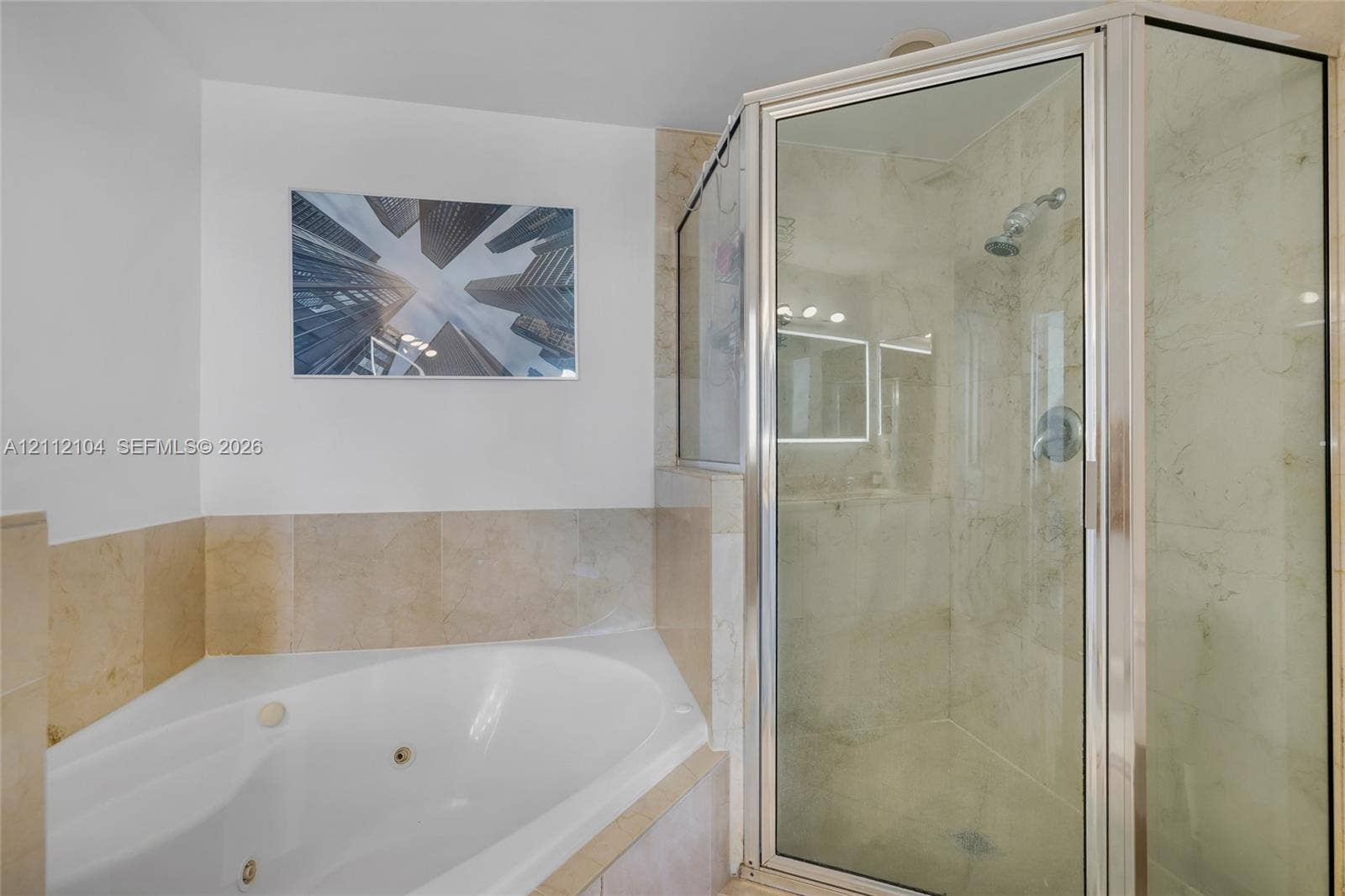 7900 Harbor Island Drive, #1203, North Bay Village, North Bay Village, FL 33141 Corner jetted soaking tub with tile surround, glass-enclosed shower featuring tile walls, and polished metal hardware