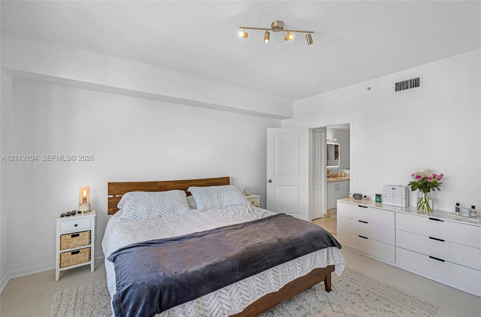 7900 Harbor Island Drive, #1203, North Bay Village, North Bay Village, FL 33141 Neutral-toned bedroom featuring minimalist interior design, four-bulb track lighting, and solid core interior door