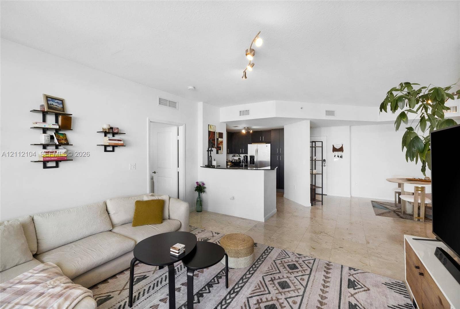 7900 Harbor Island Drive, #1203, North Bay Village, North Bay Village, FL 33141 Open-concept interior featuring large-format tile flooring, recessed and track lighting, and a kitchen peninsula with a dark countertop