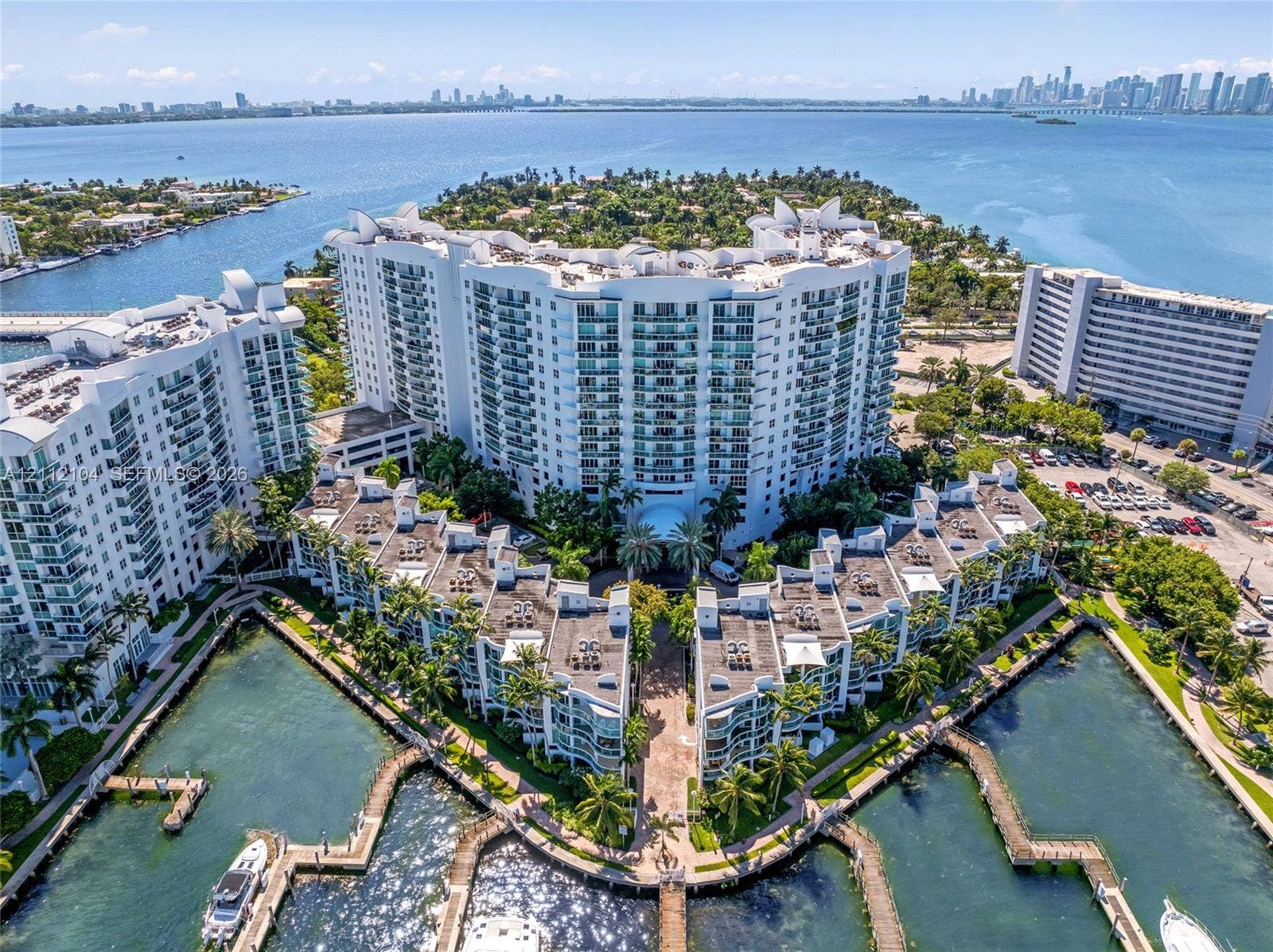 7900 Harbor Island Drive, #1203, North Bay Village, North Bay Village, FL 33141 Waterfront high-rise complex featuring private boat slips, multi-level balconies, exterior stucco finish, and landscaped grounds