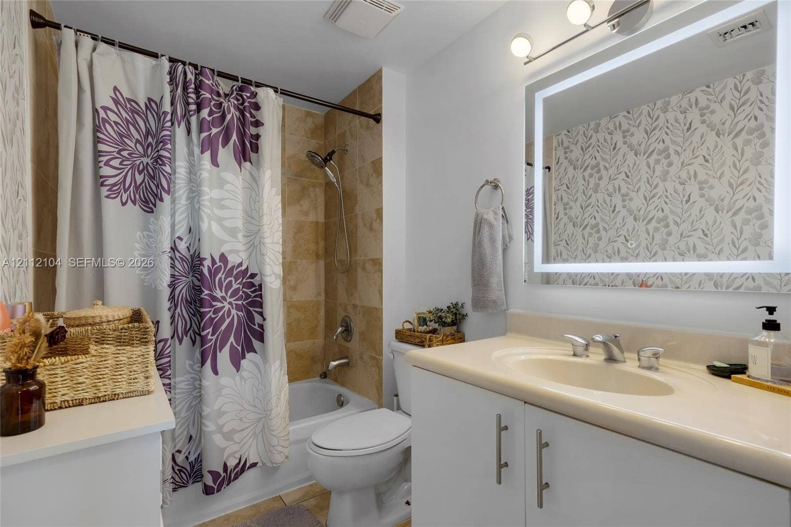 7900 Harbor Island Drive, #1203, North Bay Village, North Bay Village, FL 33141 Bathroom featuring a bathtub with tile surround, vanity with an integrated sink and countertop, backlit vanity mirror, and three-light vanity fixture