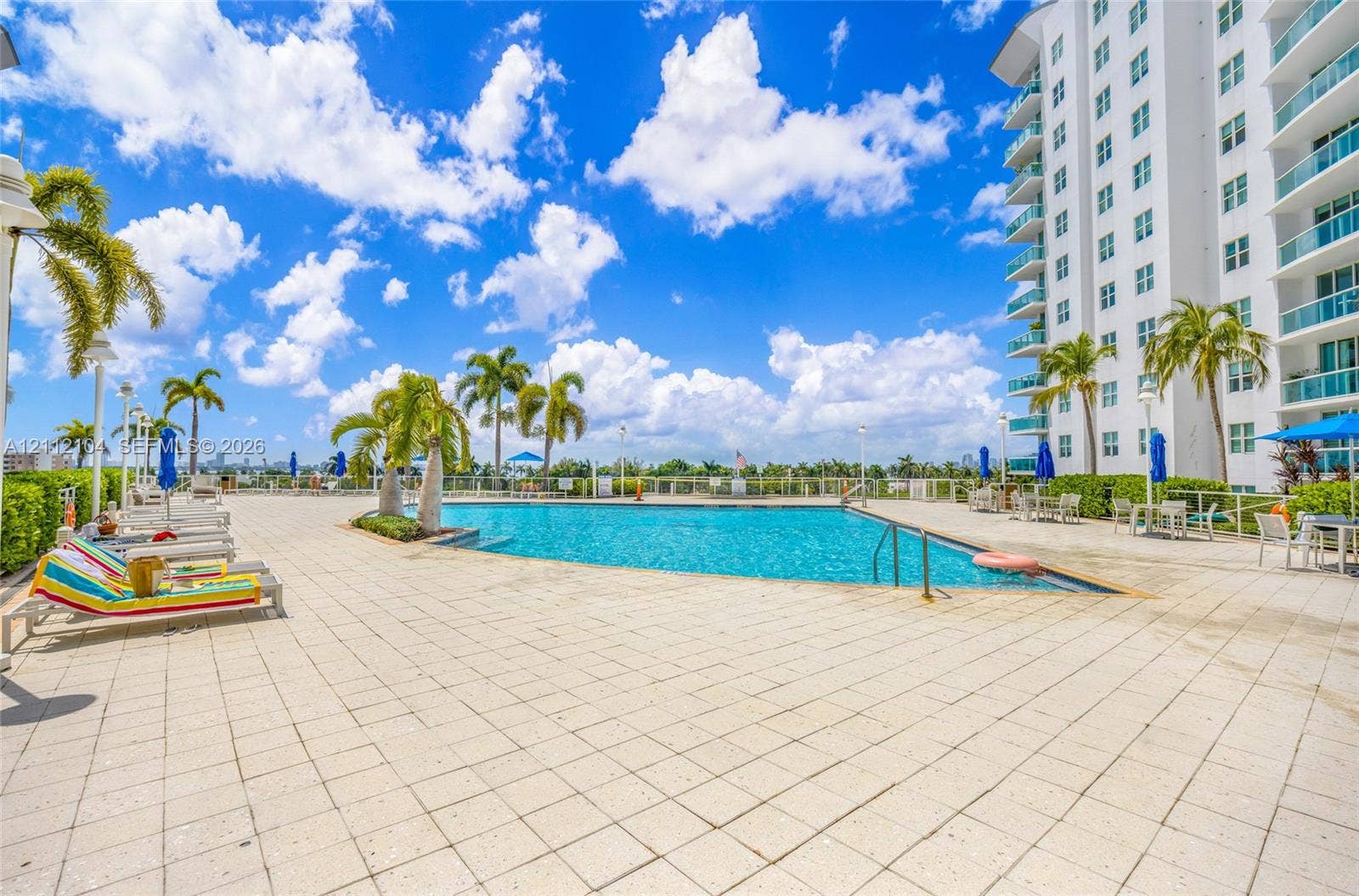 7900 Harbor Island Drive, #1203, North Bay Village, North Bay Village, FL 33141 Swimming pool with tiled decking, mature palm trees, and perimeter fencing