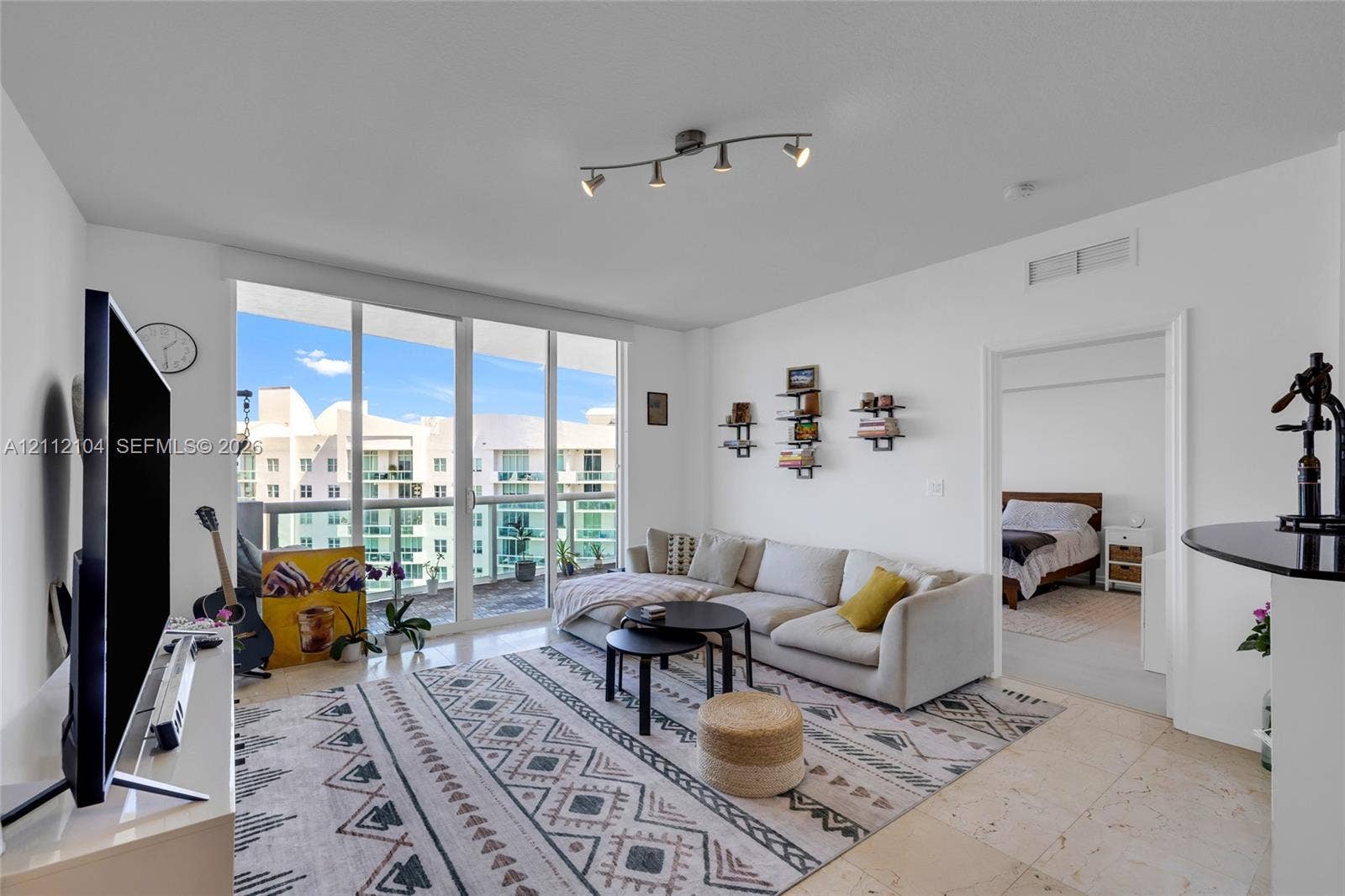 7900 Harbor Island Drive, #1203, North Bay Village, North Bay Village, FL 33141 Floor-to-ceiling glass doors, neutral stone-finish flooring, and adjustable multi-light track lighting