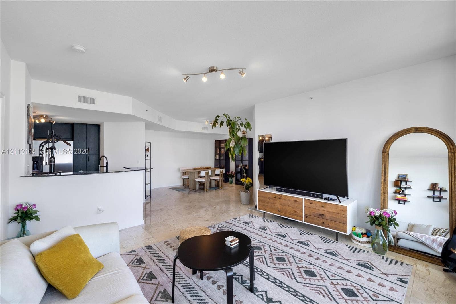 7900 Harbor Island Drive, #1203, North Bay Village, North Bay Village, FL 33141 Open-concept interior featuring light stone flooring, recessed track lighting, and a kitchen peninsula with a dark stone countertop