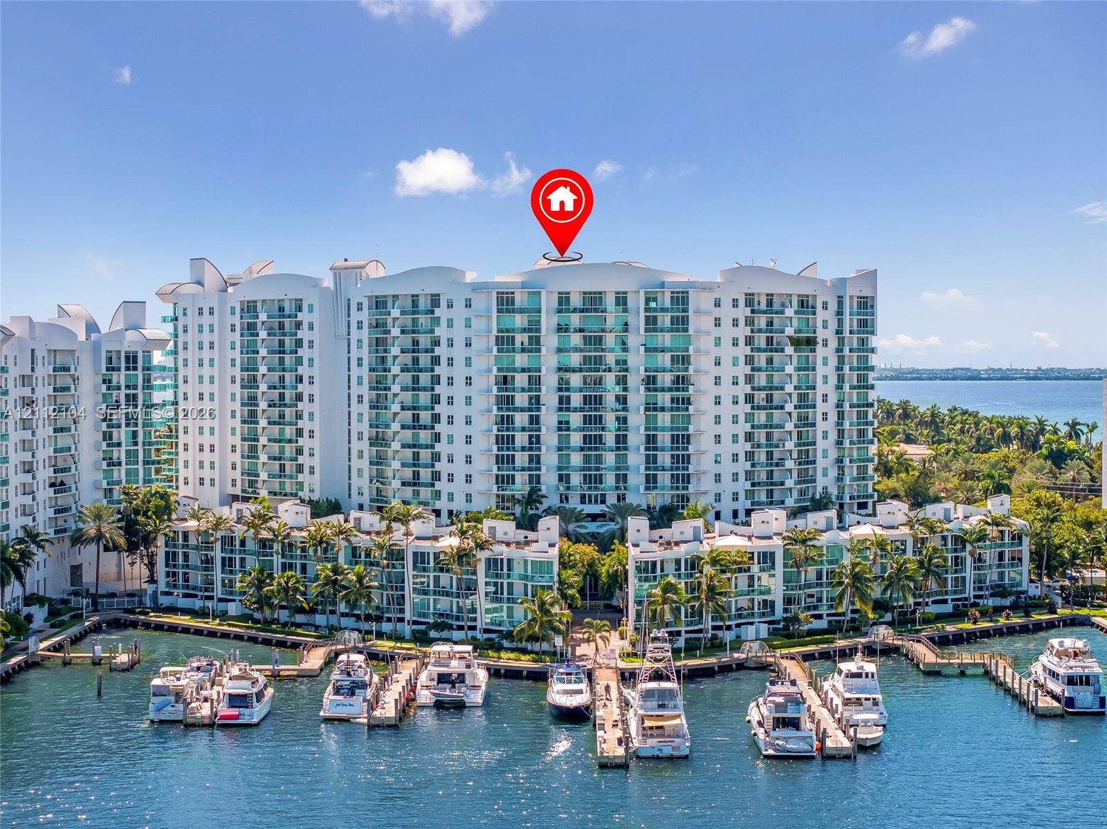 7900 Harbor Island Drive, #1203, North Bay Village, North Bay Village, FL 33141 Multi-story waterfront residential complex featuring private boat slips, balconies with glass railings, and mature palm trees