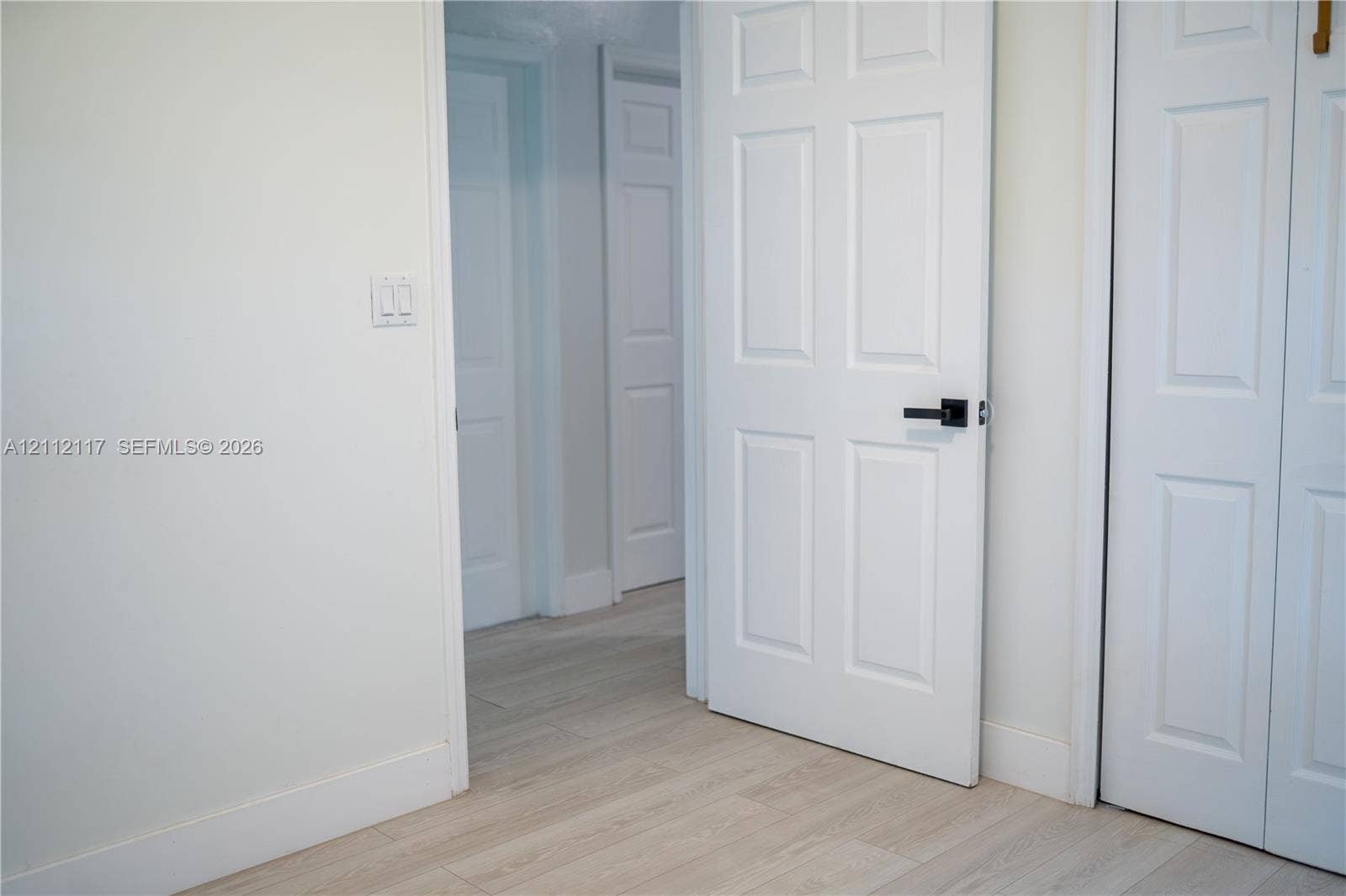 1209 NE 32nd Avenue, Homestead, Homestead, FL 33033 Interior space featuring light wood-finish flooring, six-panel interior doors, and matte black hardware