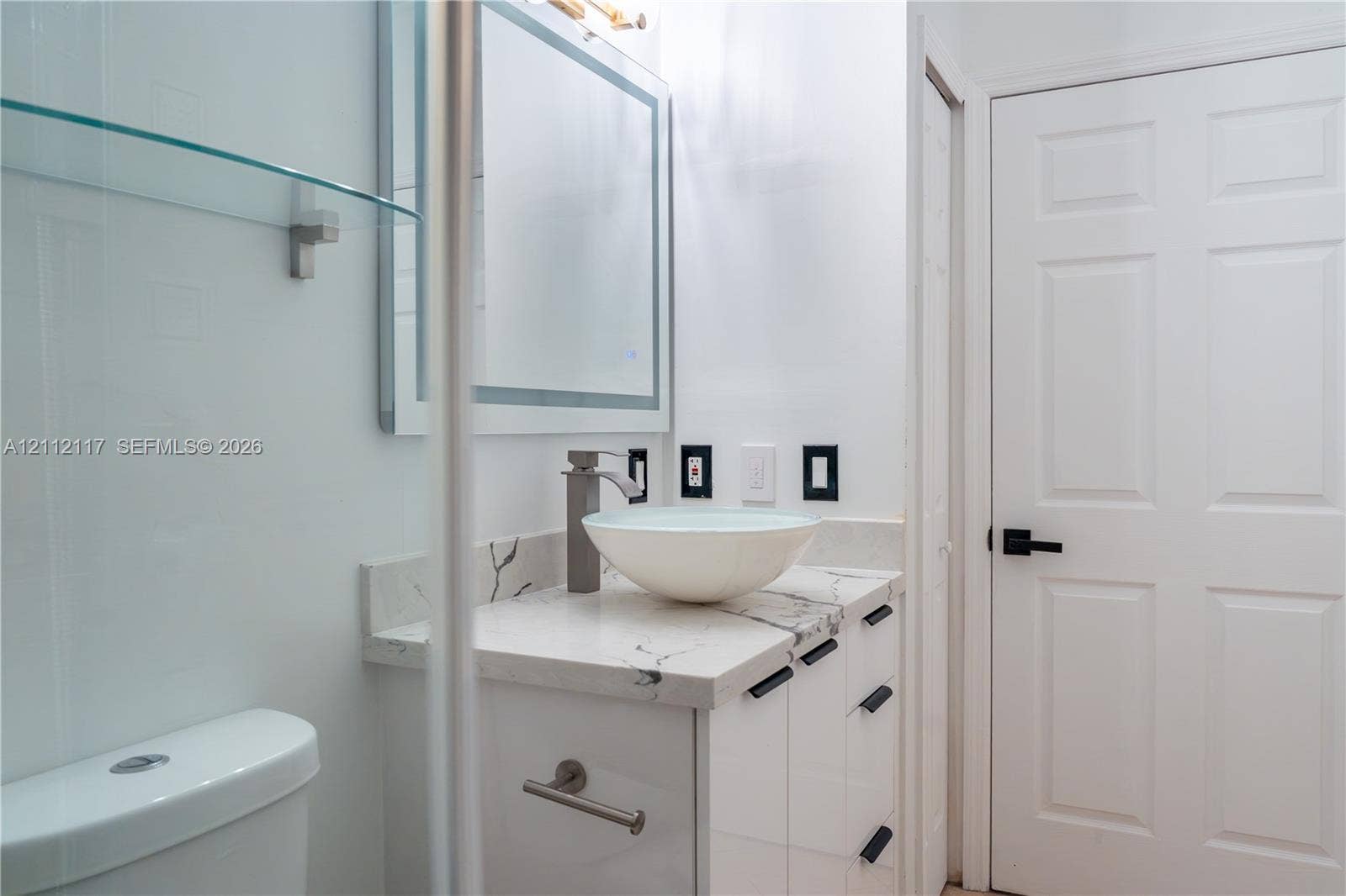 1209 NE 32nd Avenue, Homestead, Homestead, FL 33033 Bathroom vanity featuring a stone-surface countertop, vessel sink, high-profile faucet, and integrated mirror with perimeter lighting