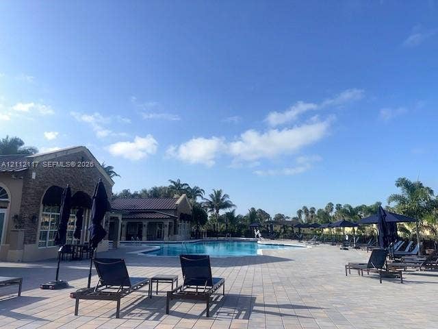 1209 NE 32nd Avenue, Homestead, Homestead, FL 33033 Outdoor swimming pool surrounded by a paved stone deck and stone-finish exterior walls