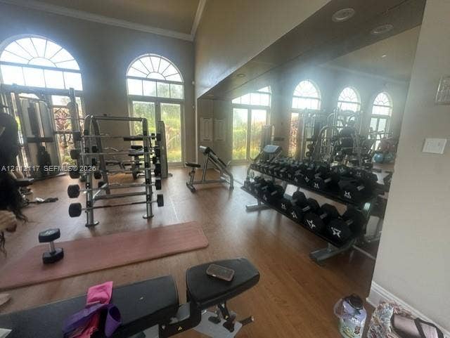 1209 NE 32nd Avenue, Homestead, Homestead, FL 33033 Spacious room featuring floor-to-ceiling wall mirrors, wood-finish flooring, recessed lighting, and arched windows with exterior access