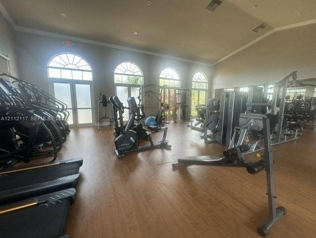 1209 NE 32nd Avenue, Homestead, Homestead, FL 33033 Fitness facility featuring arched windows, vaulted ceilings, wood-finish flooring, and wall-to-wall mirrors