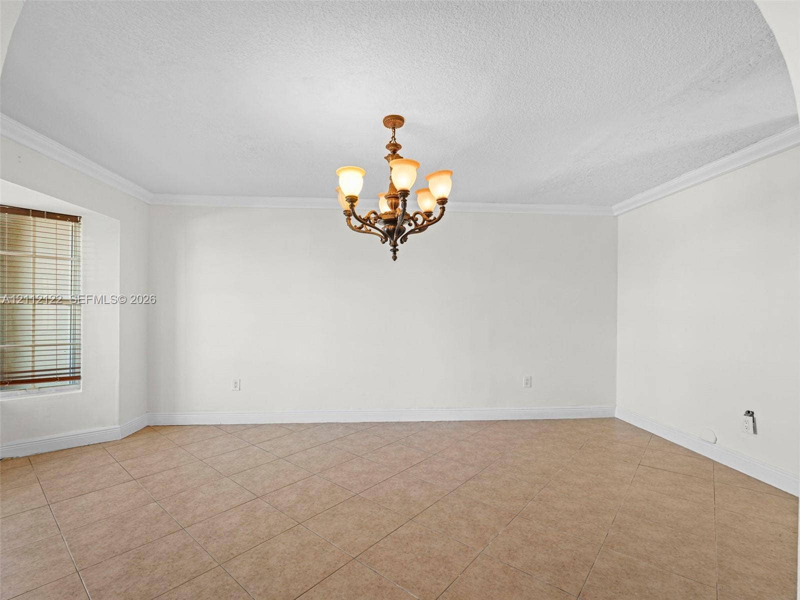 13990 SW 161st Terrace, Miami, FL 33177 Interior space featuring tile flooring, crown molding, a multi-light metal chandelier, and a window with blinds