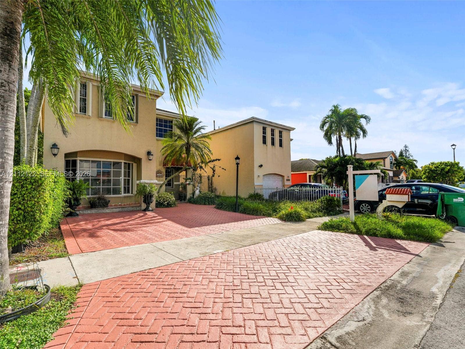 13990 SW 161st Terrace, Miami, FL 33177 Stucco exterior featuring a multi-level facade, herringbone-patterned paved driveway, bay window, and attached garage