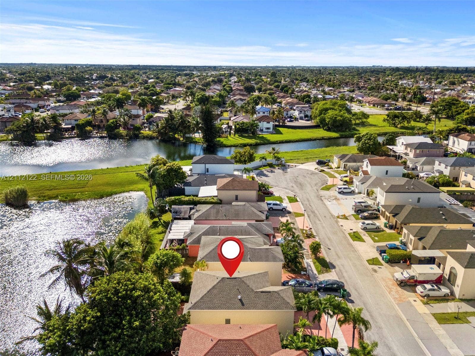 13990 SW 161st Terrace, Miami, FL 33177 Aerial perspective showcasing a residential property with a multi-level roofline, situated on a waterfront lot featuring direct canal access and mature perimeter landscaping