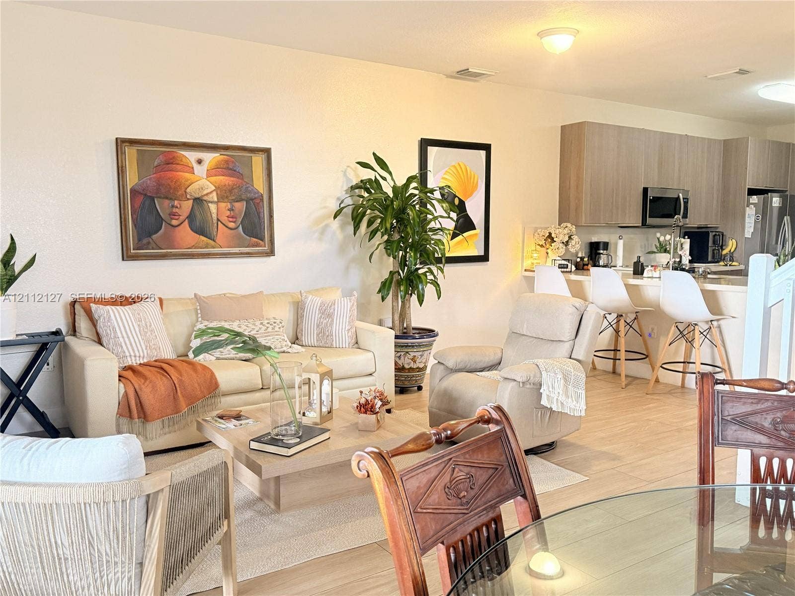 Open-concept interior featuring wood-finish flooring, recessed lighting, and a kitchen equipped with flat-panel cabinetry and a breakfast bar