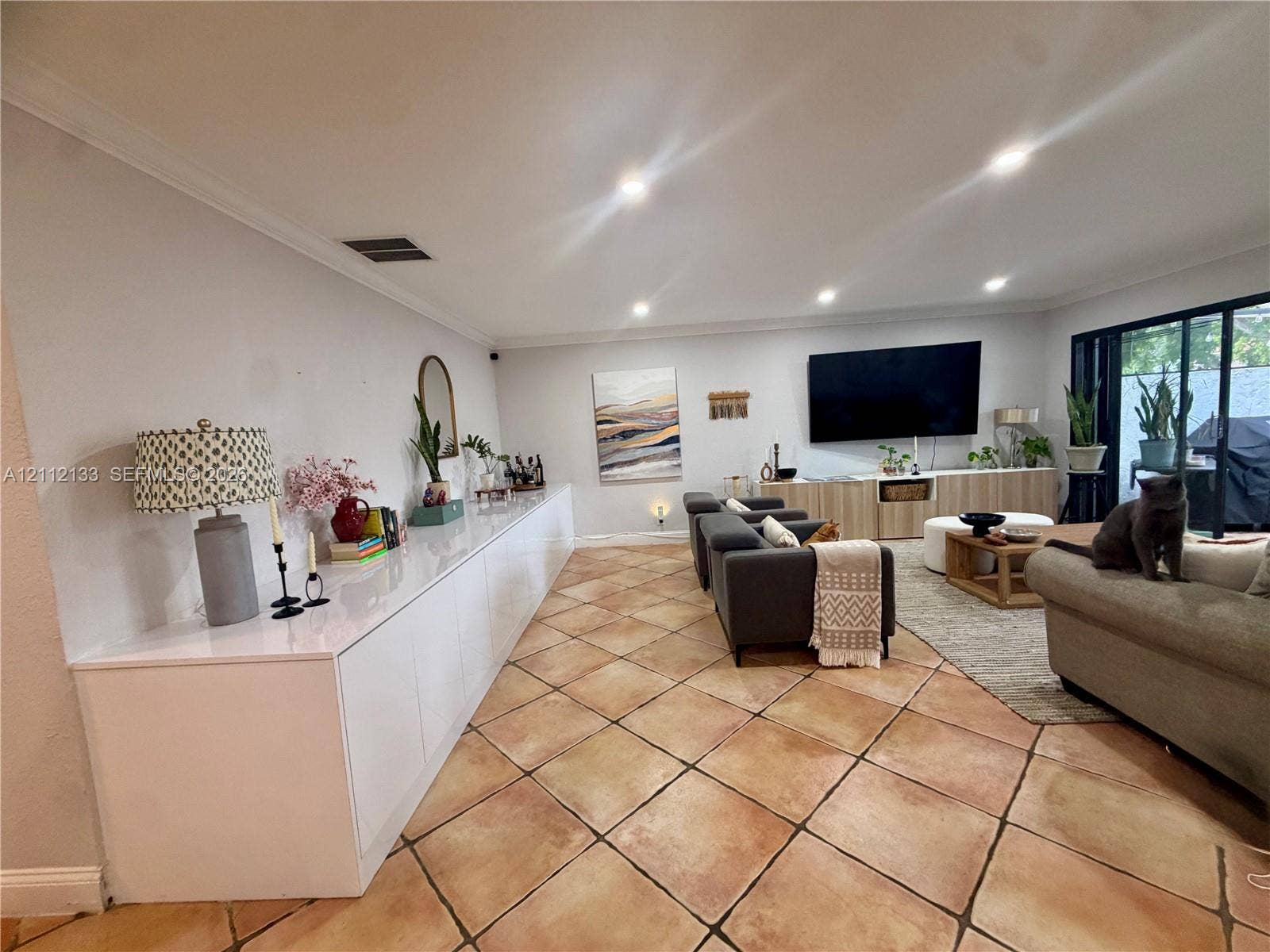 407 Bonnie Brae Way, #22, Hollywood, Hollywood, FL 33021 Spacious living area featuring diagonal-set tile flooring, expansive built-in white cabinetry, recessed lighting, and large sliding glass doors