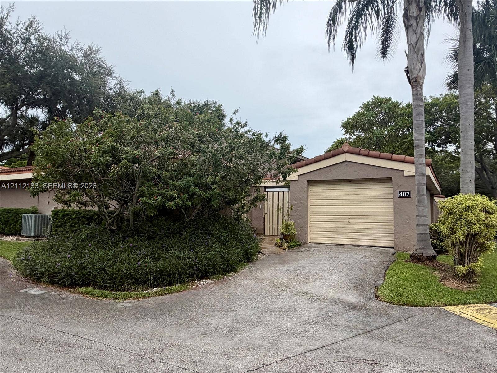 407 Bonnie Brae Way, #22, Hollywood, Hollywood, FL 33021 Stucco exterior featuring a tile roof, an attached one-car garage, and established landscaping with mature palm trees
