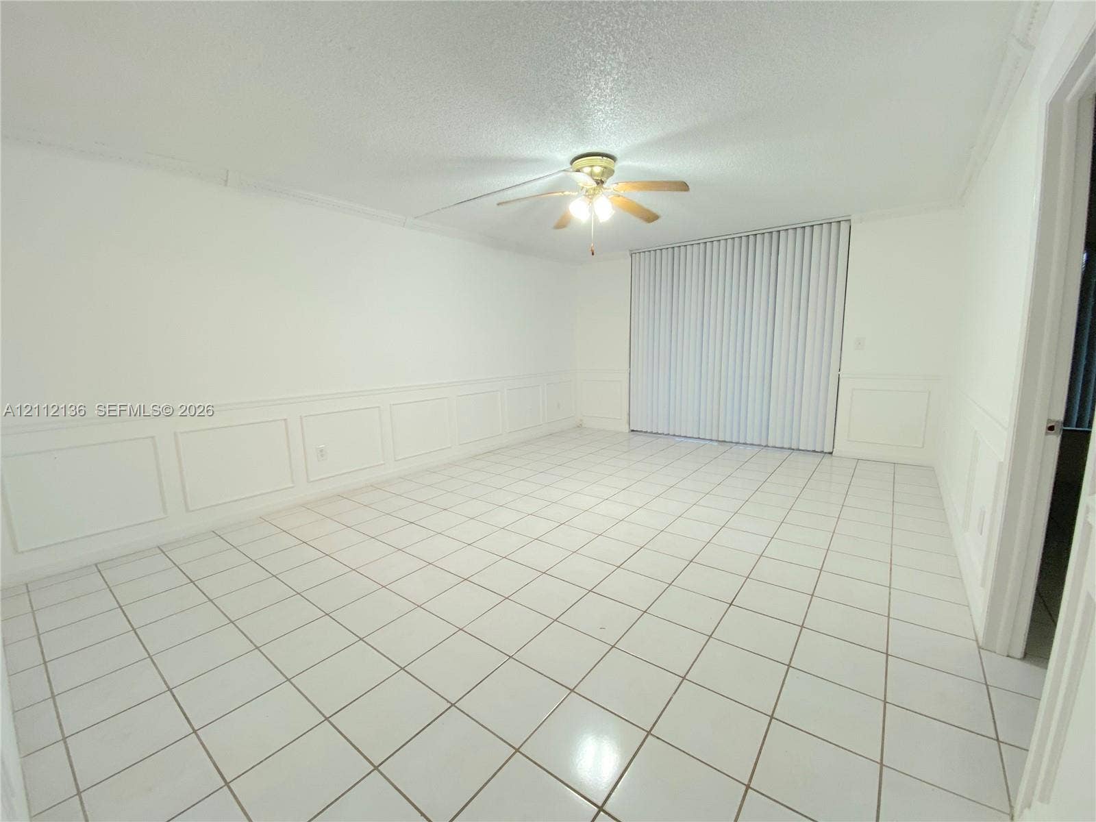 8635 NW 8th Street, #109, Miami, Miami, FL 33126 Interior space featuring tile flooring, wall wainscoting, a ceiling fan with light fixture, and vertical window blinds
