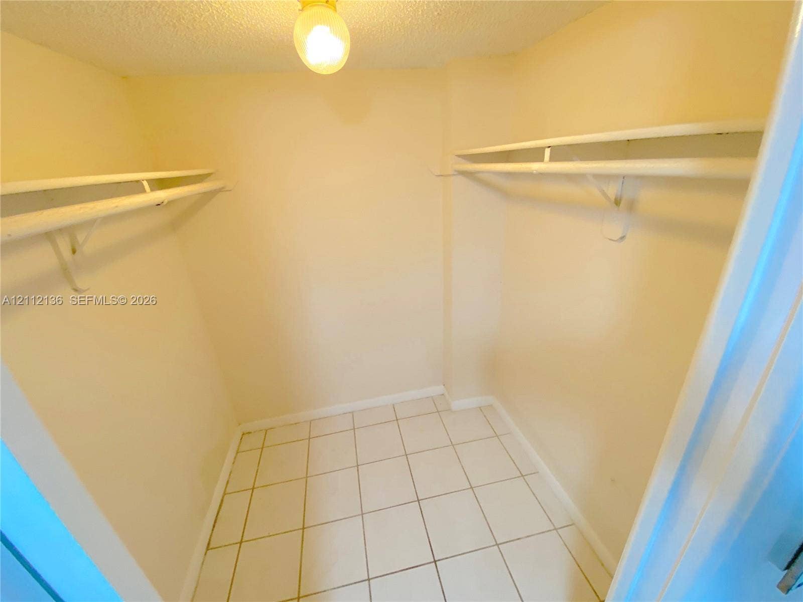 8635 NW 8th Street, #109, Miami, Miami, FL 33126 Walk-in storage space featuring ceramic tile flooring, dual-level wall-mounted shelving, and a central ceiling light fixture