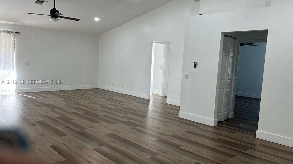 Vaulted ceilings, wood-finish flooring, recessed lighting, and a ceiling fan