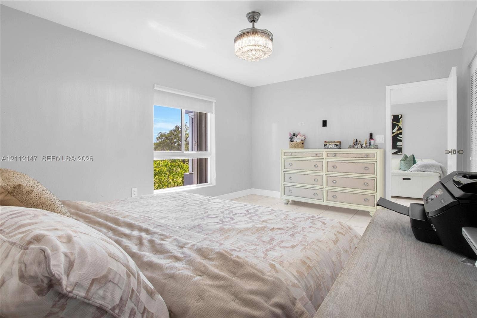 8331 Sands Point Boulevard, #C308, Tamarac, FL 33321 Neutral-toned interior featuring expansive natural light, a ceiling-mounted crystal-accented chandelier, and a single-hung window