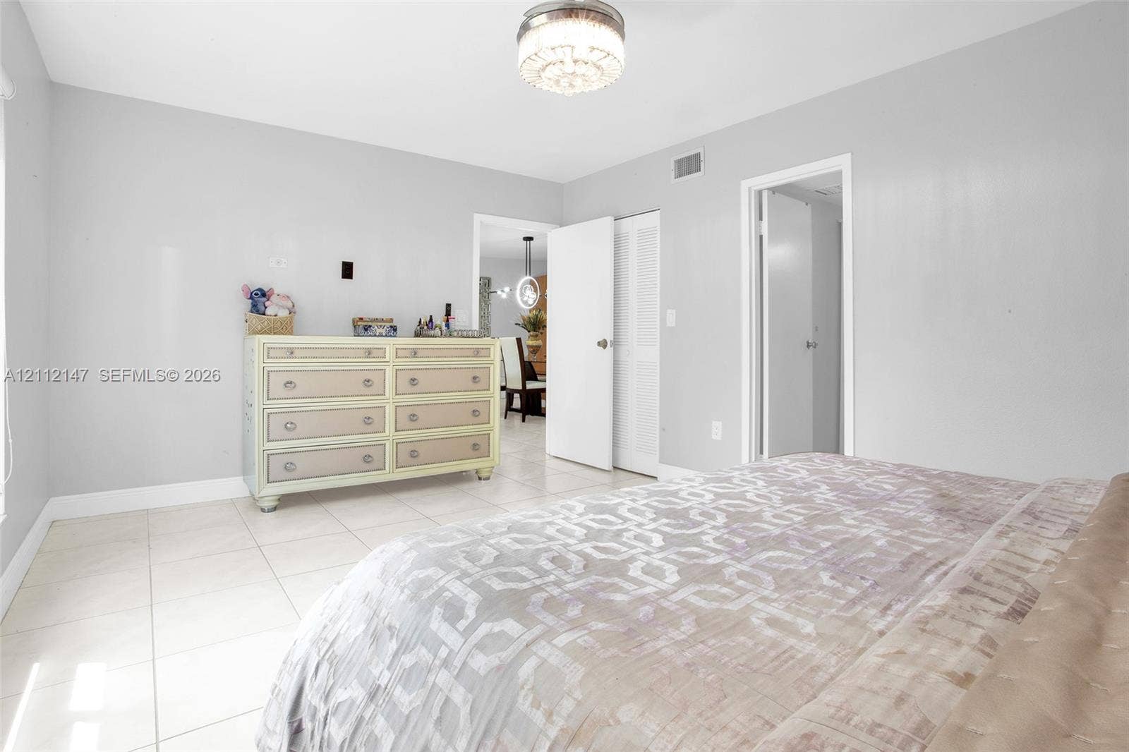8331 Sands Point Boulevard, #C308, Tamarac, FL 33321 Neutral-toned interior space featuring light-colored tile flooring, flush-mount decorative ceiling light fixture, and louvered-door closet